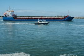 a large boat traveling past a large ship in the water